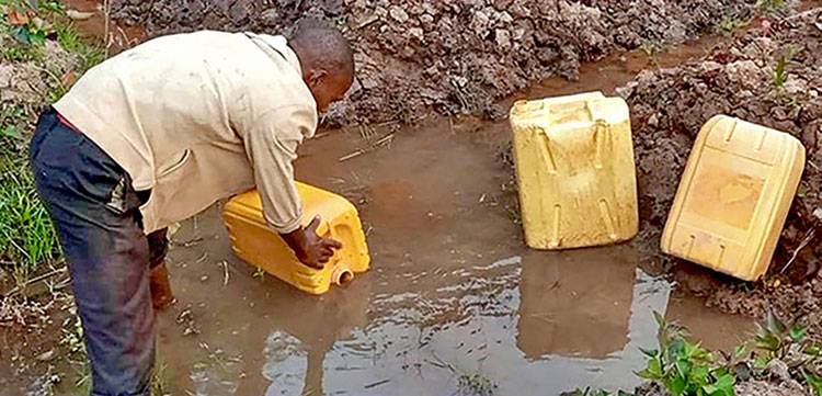 Picture of man fetching dirty water in Rwanda