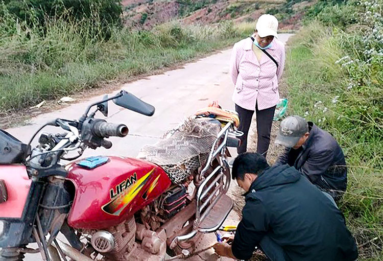 Image of missionary helping to repair motorcycle