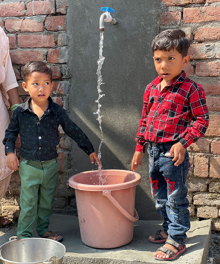 Image of two children drinking safe water